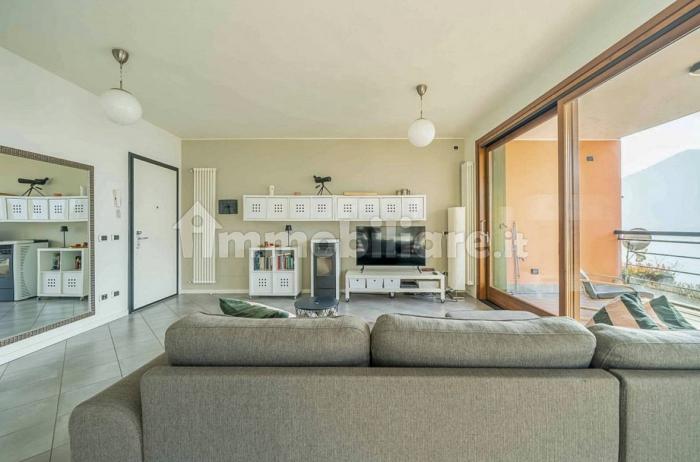 Großzügiger Wohn-/Essbereich mit Panoramafenster, Pelletofen, SAT-TV und direktem Zugang zum großen, möblierten 20 m² Balkon mit spektakulärem Seeblick