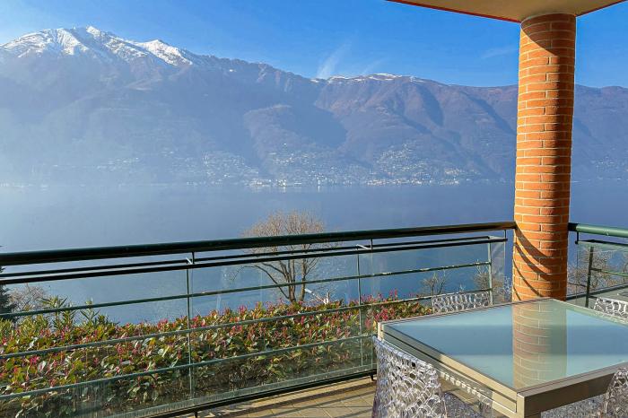 Ca. 20 m² großer überdachter Balkon mit Blick auf den Lago Maggiore, die umliegenden Berge und die leuchtenden Brissago-Inseln – ein Postkartenmotiv bei Sonnenuntergang!