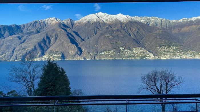 Ca. 20 m² großer überdachter Balkon mit Blick auf den Lago Maggiore, die umliegenden Berge und die leuchtenden Brissago-Inseln – ein Postkartenmotiv bei Sonnenuntergang!