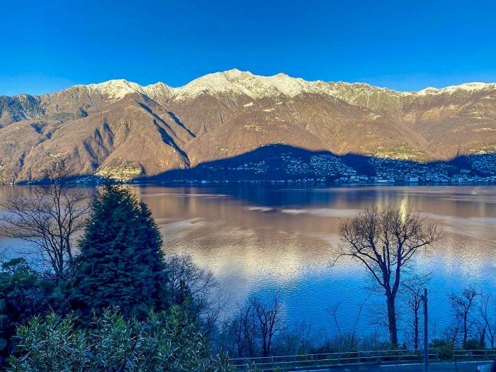 Ca. 20 m² großer überdachter Balkon mit Blick auf den Lago Maggiore, die umliegenden Berge und die leuchtenden Brissago-Inseln – ein Postkartenmotiv bei Sonnenuntergang!