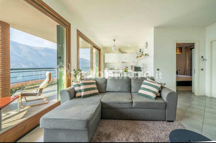 Großzügiger Wohn-/Essbereich mit Panoramafenster, Pelletofen, SAT-TV und direktem Zugang zum großen, möblierten 20 m² Balkon mit spektakulärem Seeblick