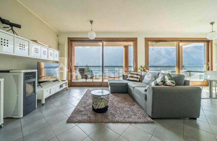 Großzügiger Wohn-/Essbereich mit Panoramafenster, Pelletofen, SAT-TV und direktem Zugang zum großen, möblierten 20 m² Balkon mit spektakulärem Seeblick