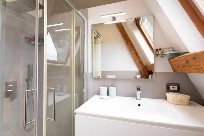 Modernes helles Badezimmer mit großer Dusche, Regenduschfunktion, WC, Bidet und Handtuchheizkörper