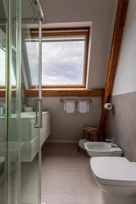 Modernes helles Badezimmer mit großer Dusche, Regenduschfunktion, WC, Bidet und Handtuchheizkörper