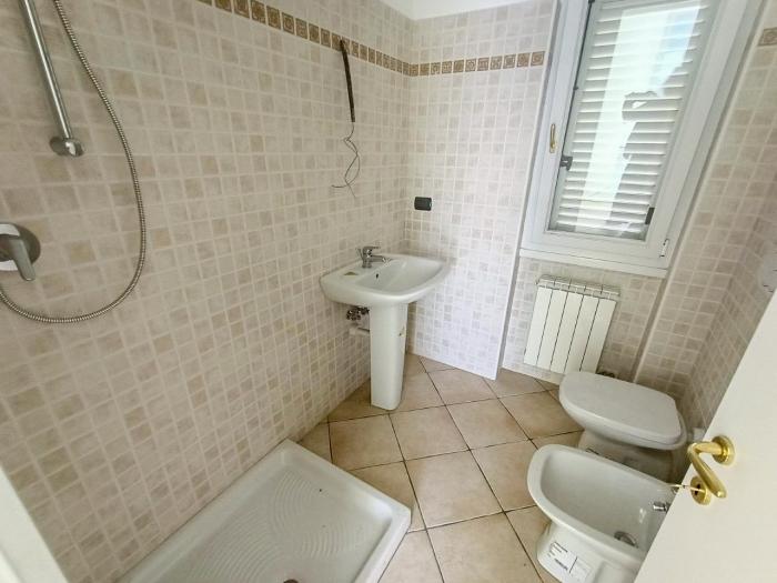Freundliches Badezimmer mit Fenster, Dusche, Bidet und WC