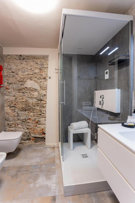 Modernes Badezimmer mit großer Dusche, Regenduschfunktion, WC, Bidet und Handtuchheizkörper