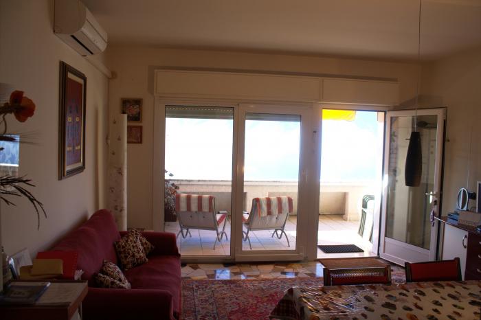 Wohn-/ Esszimmer mit großen Panoramaschiebetüren und gigantischer Sicht auf den See und die Berge